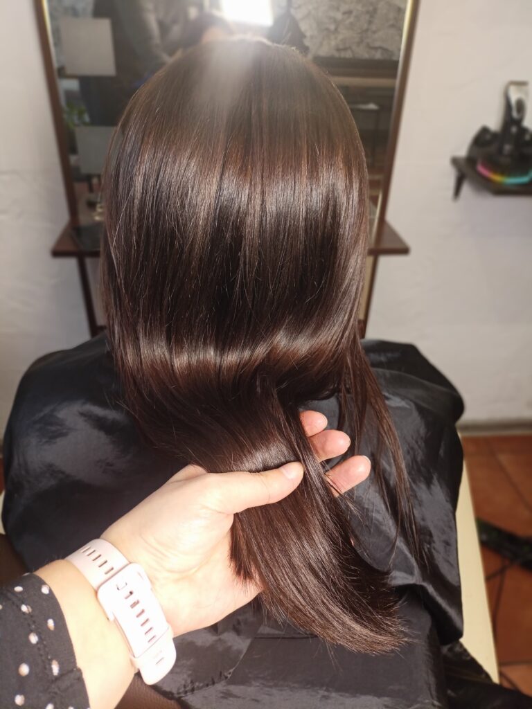 Lśniące i zdrowe ciemne włosy po odżywczym rytuale laminacji w salonie fryzjerskim Colors Premium Słubice.