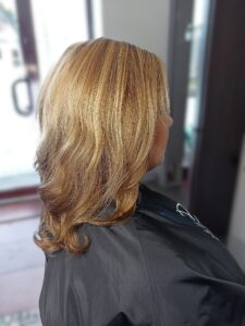 Zbliżenie na chłodne, beżowe pasemka blond, pokazujące precyzję koloryzacji i zdrowy wygląd włosów.