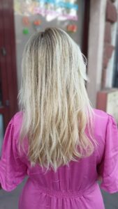 Bardzo jasny, platynowy blond z ciemniejszym odrostem na długich włosach - koloryzacja w salonie Colors.