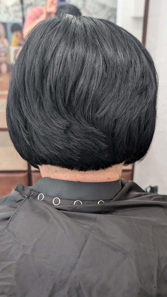 Odważna metamorfoza fryzury z blondu na kruczoczarny kolor i precyzyjne cięcie w stylu bob, wykonana w salonie Colors Premium w Słubicach.