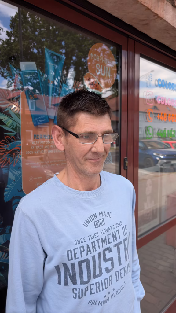 Mężczyzna z elegancko ułożoną, krótką fryzurą po zabiegu dyskretnego odsiwiania włosów, które odzyskały swój naturalny, ciemny kolor.