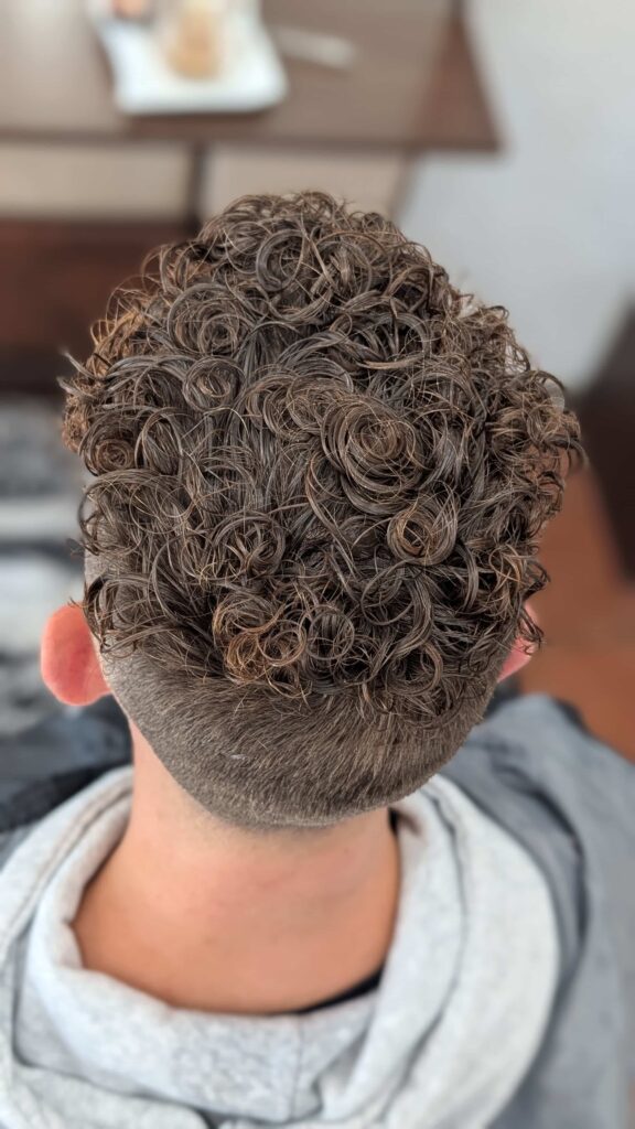 Widok z góry na męską trwałą ondulację z efektem naturalnych, gęstych fal.